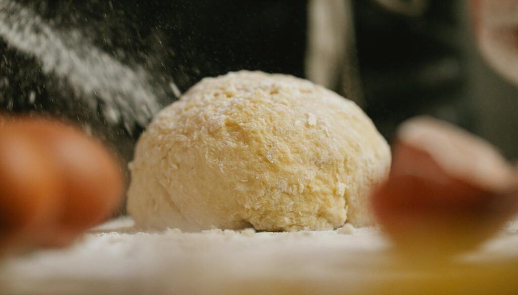 dough with flour and eggshell in kitchen